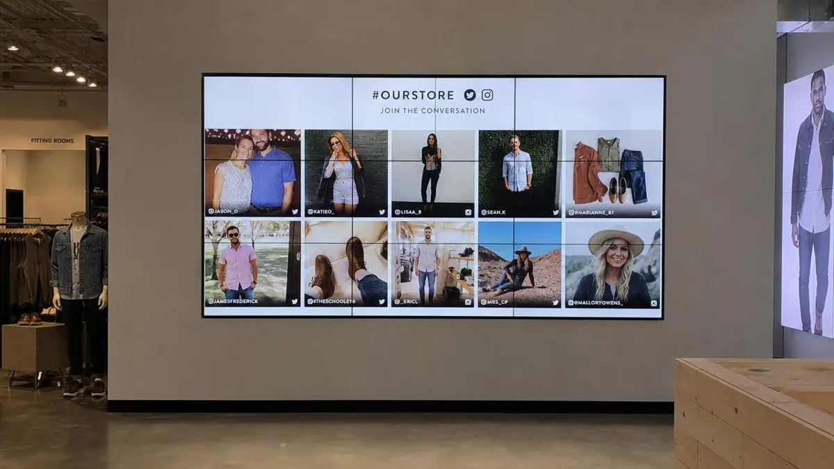 Retail store wall screen displaying a grid of customer social media photos with a store hashtag